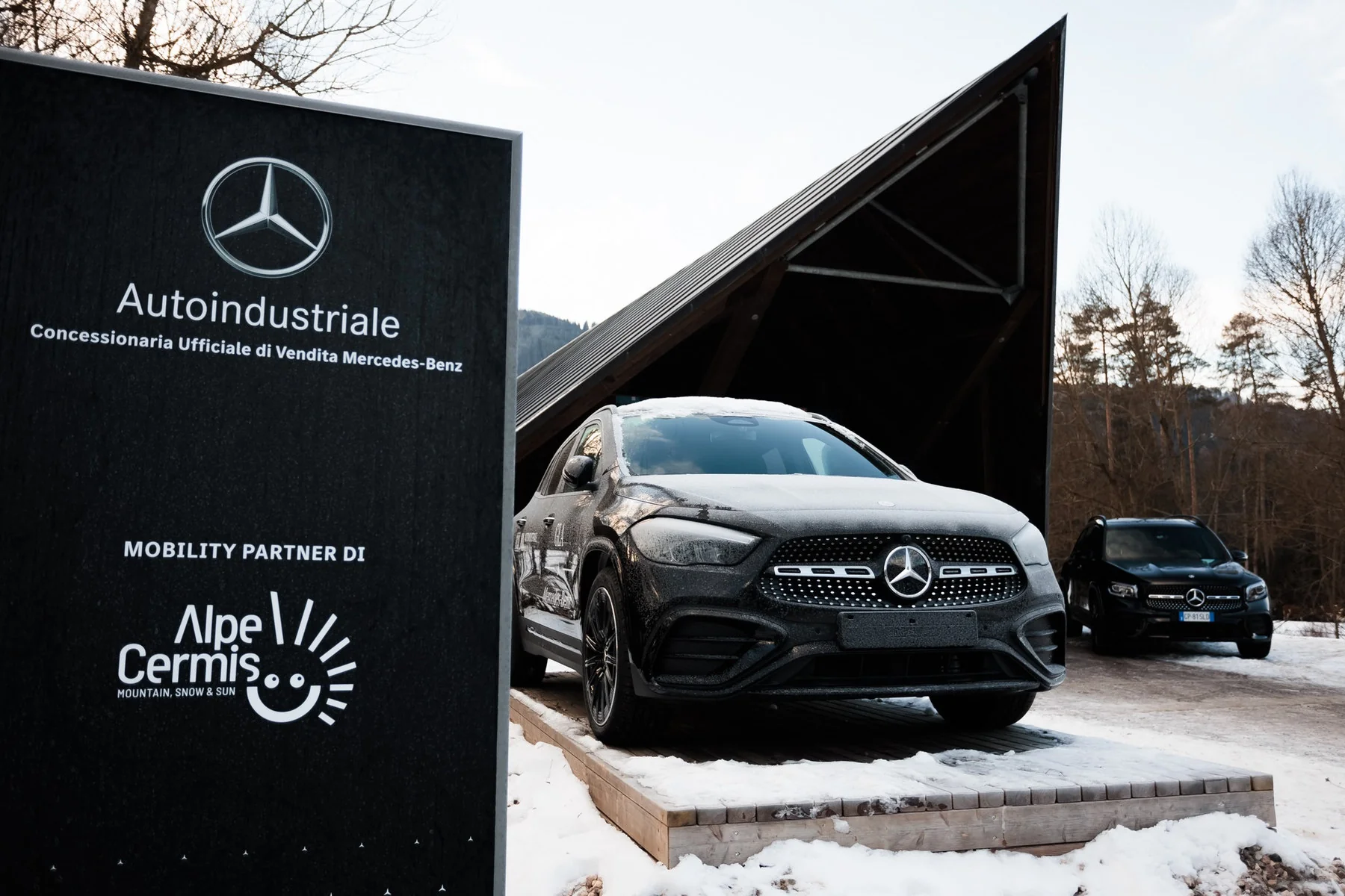 Mercedes-Benz esposta sulla pedana in legno a valle dell’Alpe del Cermis, accanto al totem del brand.